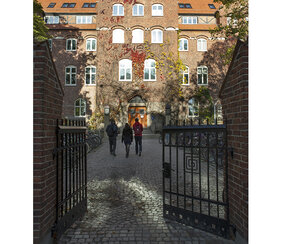 Tre personer går mot entré till byggnaden LUX. Foto.